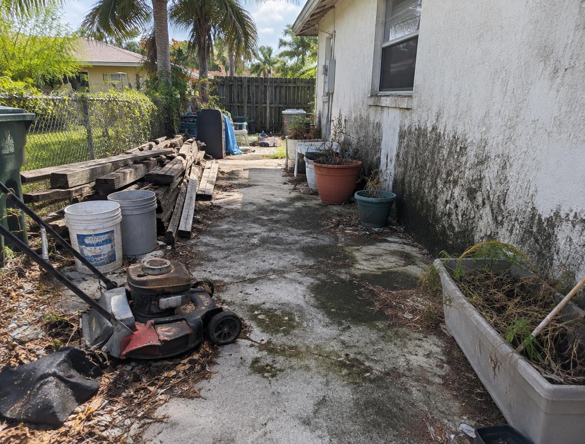 Outdoor area cleared & pressure-washed — before